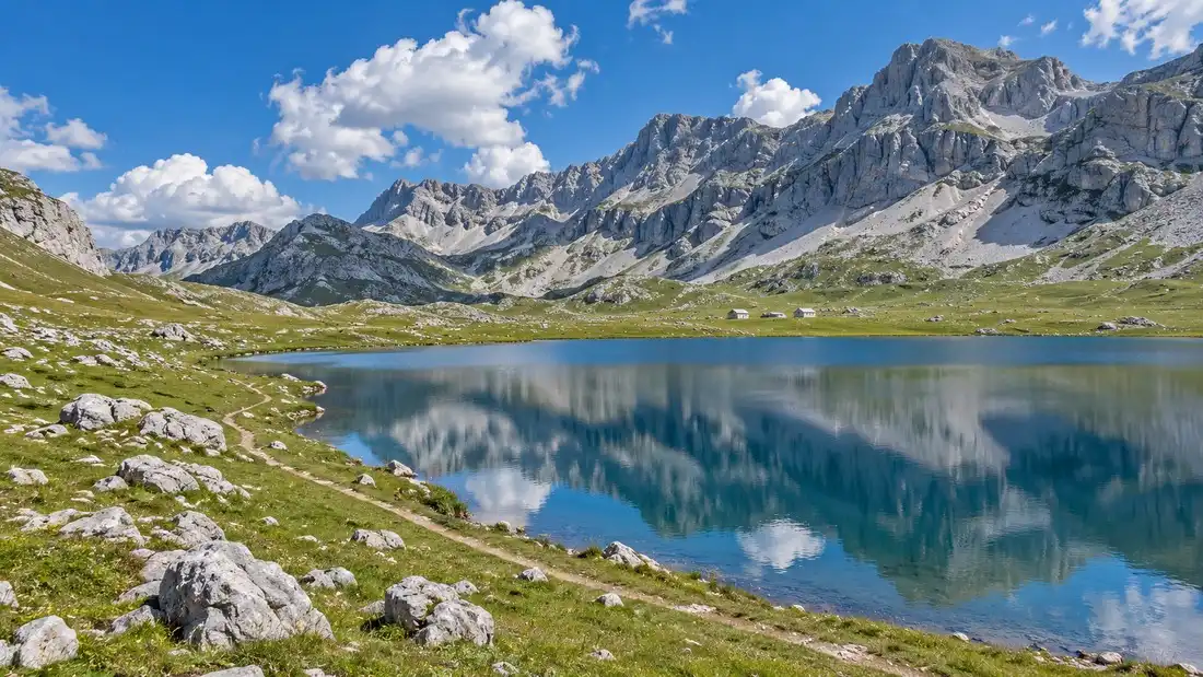 Ledovcové Kapetanovo jezero na holé vápencové plošině Lukavica, v pozadí zaoblený bezlesý hřeben